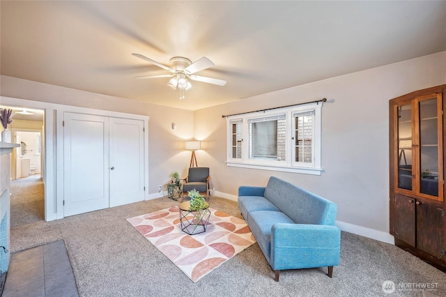 living area featuring a ceiling fan, carpet flooring, and baseboards