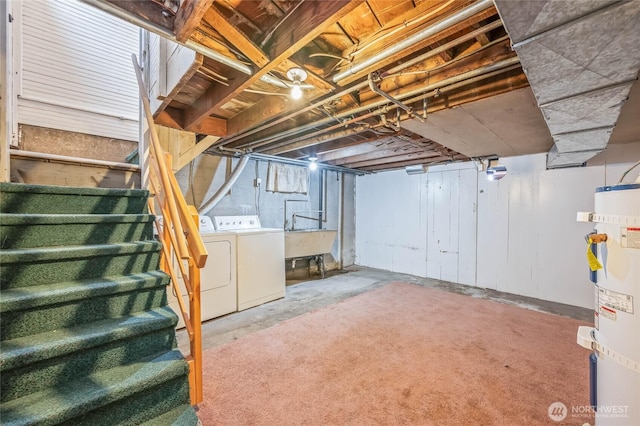 unfinished below grade area with stairs, water heater, washer and clothes dryer, and a sink