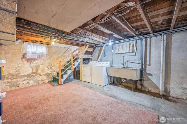 below grade area featuring washing machine and dryer, stairs, and a sink