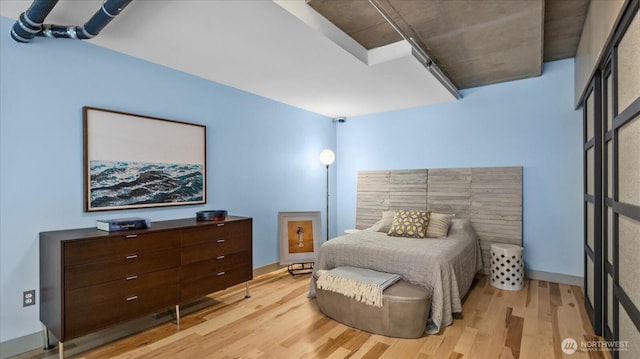 bedroom featuring light wood-type flooring and baseboards