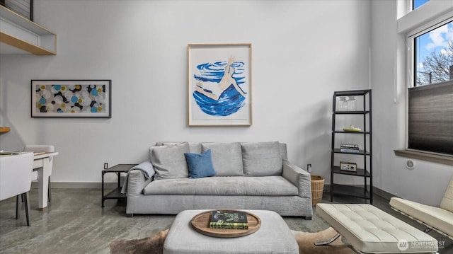 living room featuring finished concrete flooring and baseboards