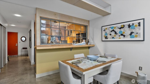 dining space with finished concrete flooring and baseboards