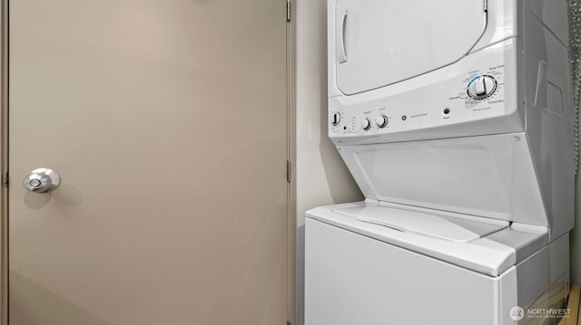 clothes washing area featuring stacked washing maching and dryer and laundry area