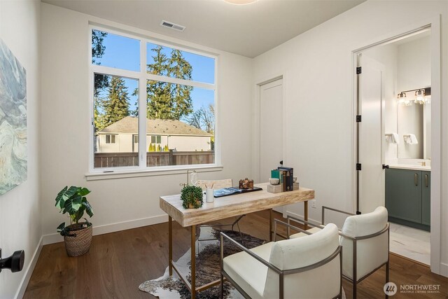 office space featuring dark wood-style flooring, visible vents, and baseboards