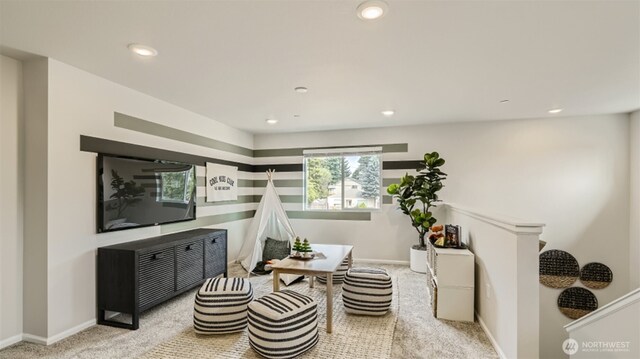 living area with recessed lighting, light carpet, and baseboards