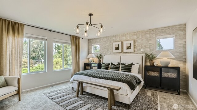 bedroom with baseboards, an inviting chandelier, and light colored carpet