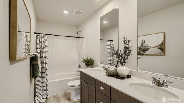 bathroom featuring toilet, shower / bath combo, a sink, and visible vents