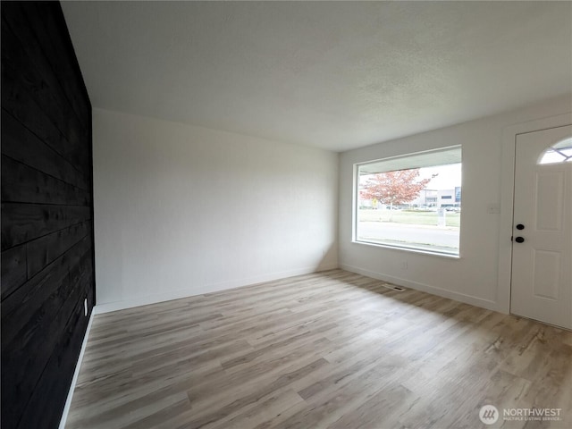 entryway with light wood-style flooring and baseboards