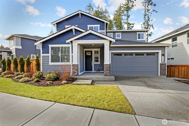 craftsman inspired home with a front yard, fence, and driveway