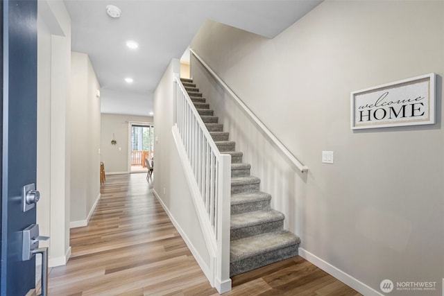 staircase with recessed lighting, wood finished floors, and baseboards