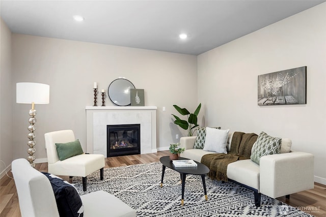 living room featuring recessed lighting, baseboards, wood finished floors, and a tile fireplace