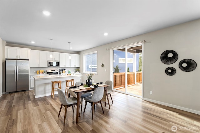 dining area with light wood finished floors, baseboards, and recessed lighting