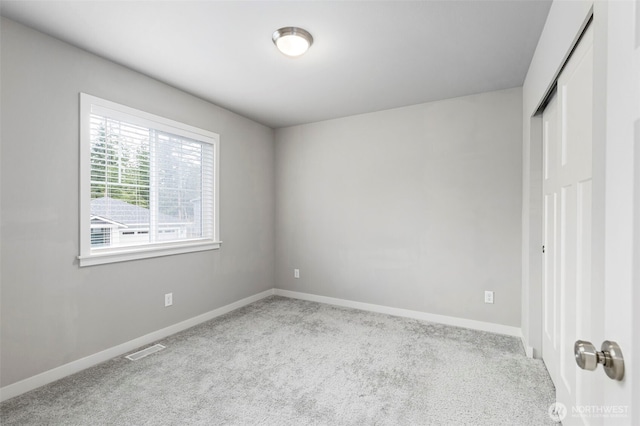 unfurnished bedroom with light colored carpet, a closet, visible vents, and baseboards