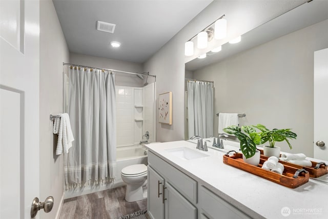 bathroom with shower / tub combo with curtain, visible vents, toilet, vanity, and wood finished floors