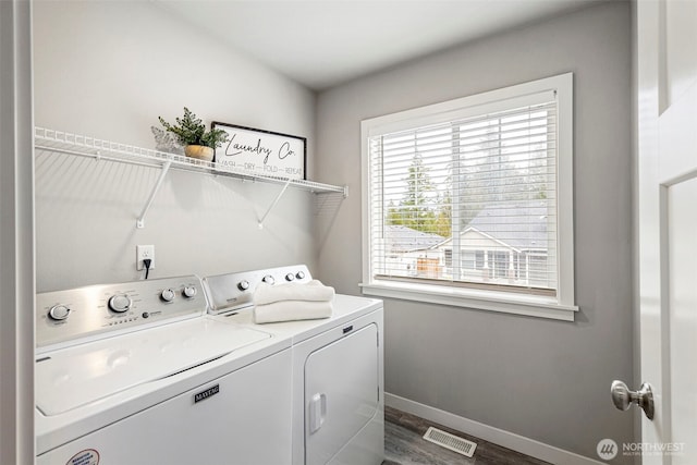 clothes washing area featuring laundry area, dark wood-type flooring, visible vents, baseboards, and washer and clothes dryer