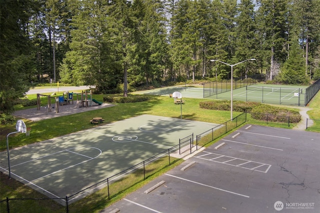 view of basketball court featuring a yard, playground community, a tennis court, community basketball court, and fence