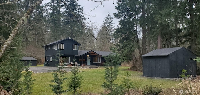 exterior space with an outbuilding, driveway, and a front yard