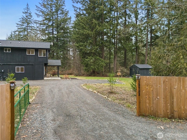 view of street featuring a gated entry and gravel driveway