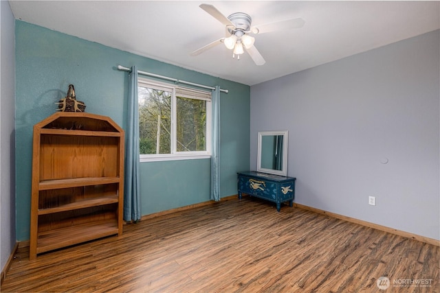 interior space featuring wood finished floors, a ceiling fan, and baseboards