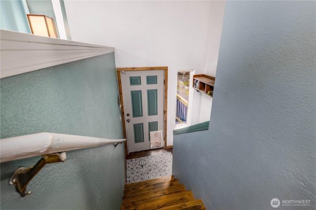 staircase featuring a textured wall