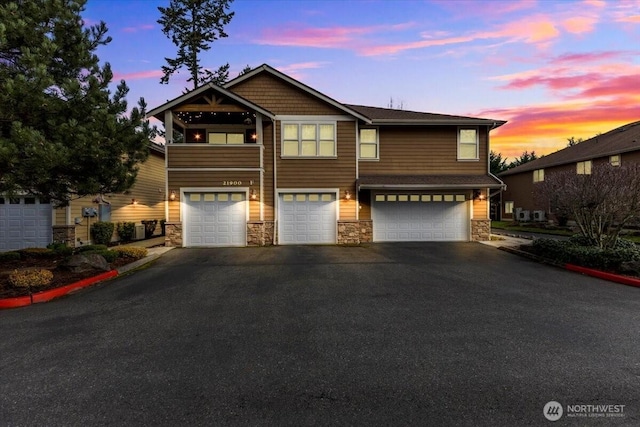 view of front of house with stone siding, driveway, and an attached garage