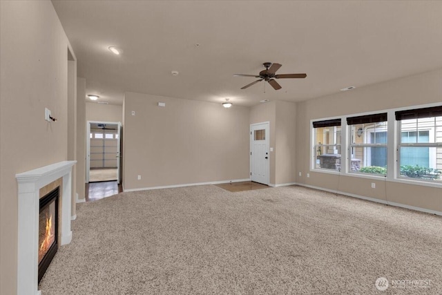 unfurnished living room featuring carpet, baseboards, and a tile fireplace