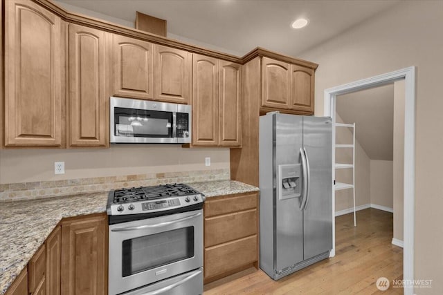 kitchen with light stone counters, recessed lighting, baseboards, light wood-style floors, and appliances with stainless steel finishes