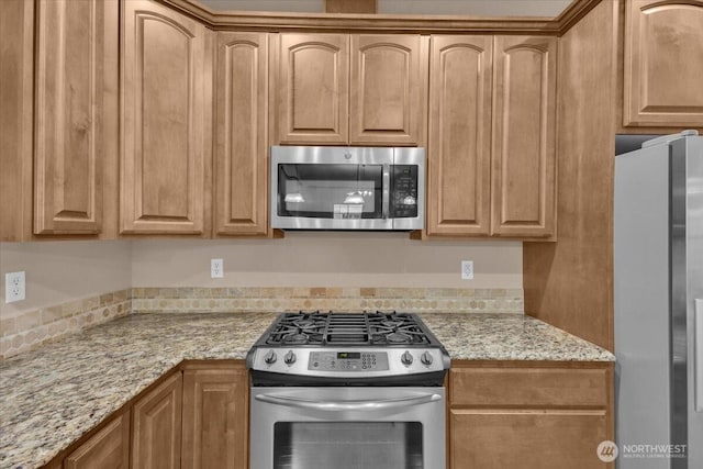 kitchen with appliances with stainless steel finishes and light stone countertops