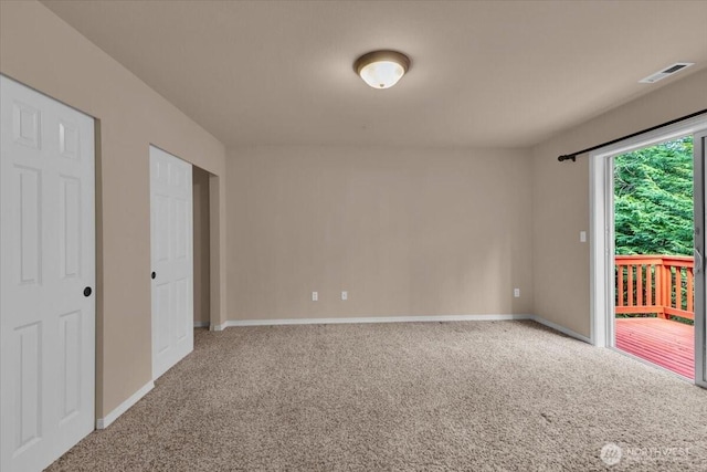 carpeted spare room with visible vents and baseboards