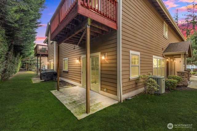 property exterior at dusk with central AC, a lawn, and a patio