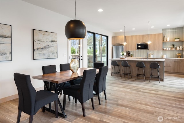 dining room featuring baseboards, light wood-type flooring, and recessed lighting