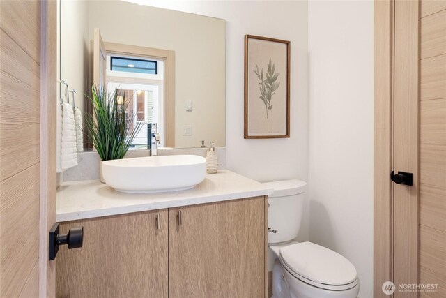 half bathroom with vanity and toilet