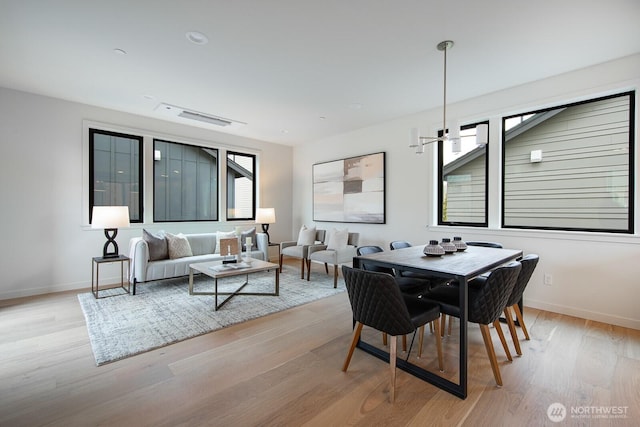 dining space featuring a wealth of natural light, baseboards, and light wood finished floors