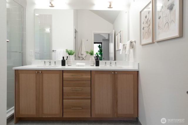 bathroom featuring double vanity, a stall shower, and a sink