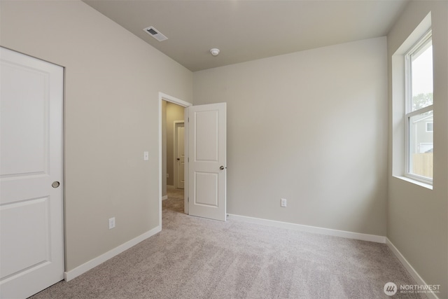 unfurnished bedroom with light carpet, baseboards, and visible vents