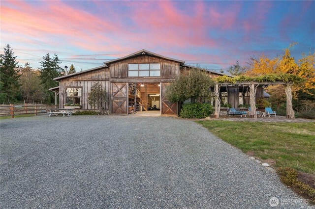 exterior space featuring a garage, gravel driveway, a barn, and an outdoor structure