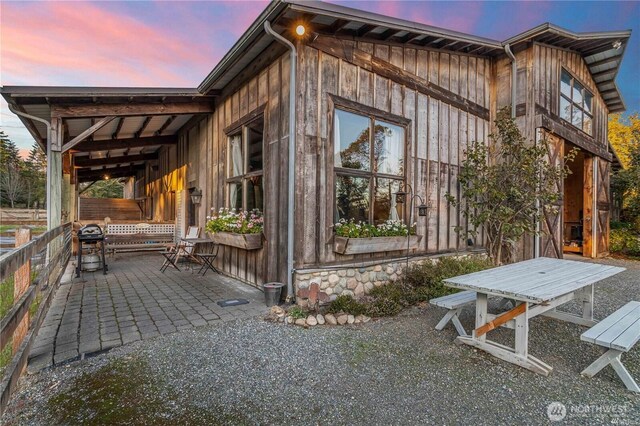 property exterior at dusk with a patio area