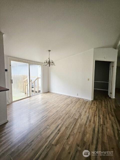 unfurnished living room with a chandelier and dark wood-style flooring