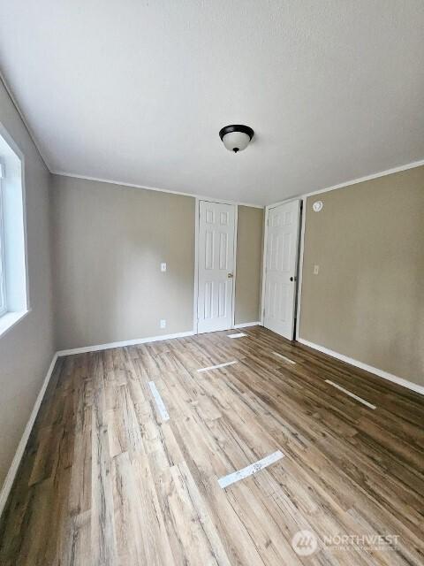 interior space with wood finished floors and baseboards