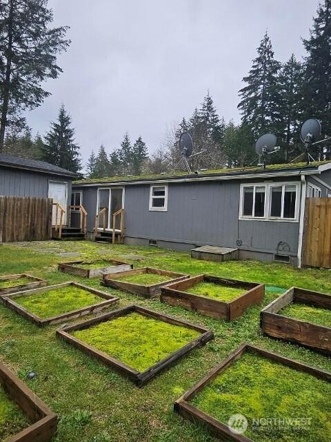 back of property featuring a vegetable garden