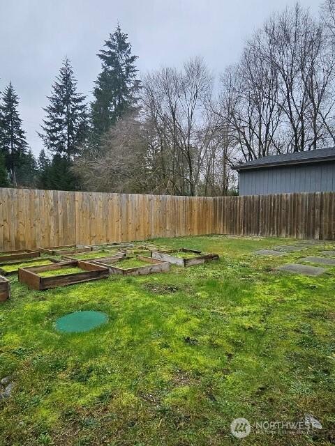 view of yard featuring a garden and a fenced backyard