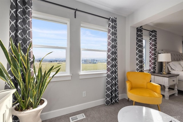 sitting room with carpet floors, baseboards, and visible vents