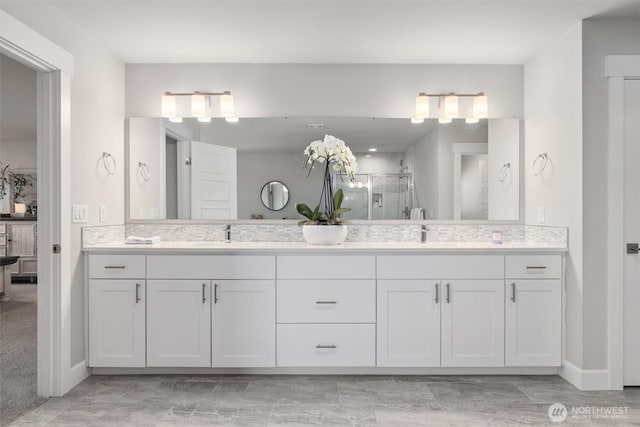 bathroom featuring double vanity, a shower stall, and a sink