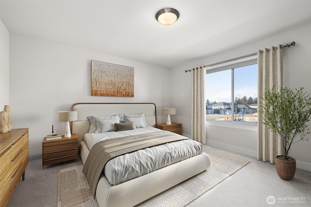 bedroom with light colored carpet and baseboards