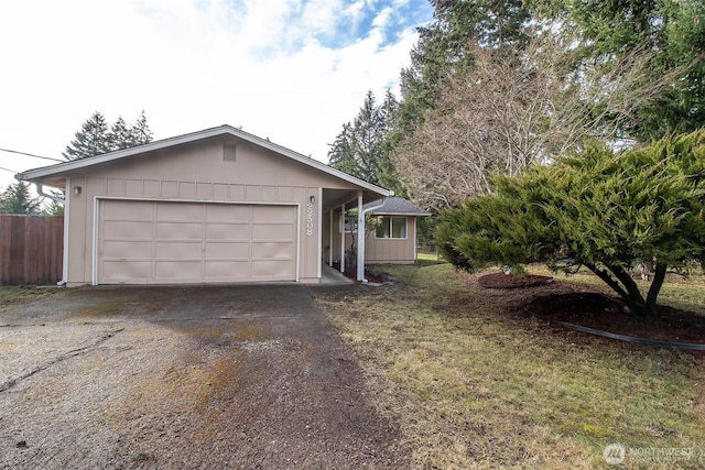 single story home with driveway, an attached garage, fence, a front lawn, and board and batten siding