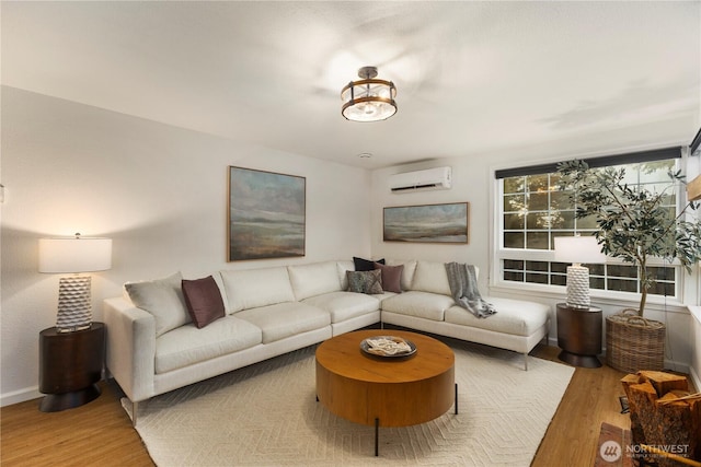 living room with a wall unit AC, baseboards, and wood finished floors