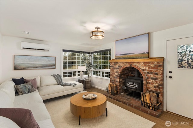 living room with wood finished floors, a wood stove, and a wall mounted AC