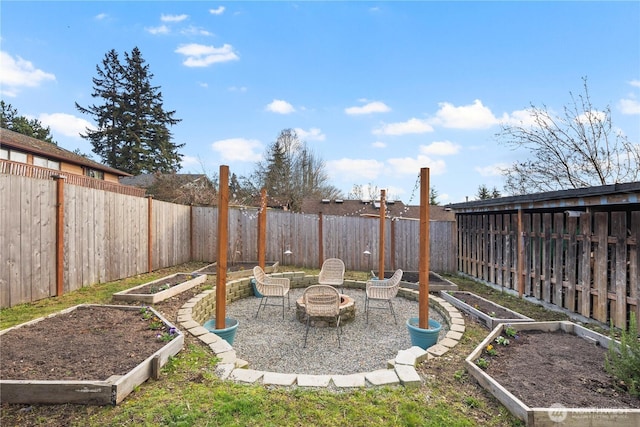 view of yard with an outdoor fire pit, a fenced backyard, and a garden