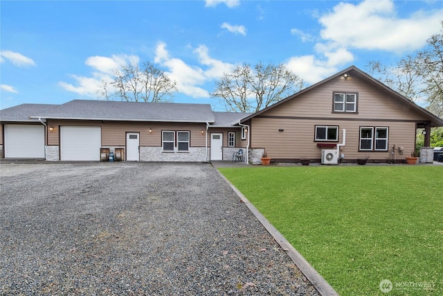 view of front facade featuring gravel driveway, stone siding, an attached garage, and a front lawn