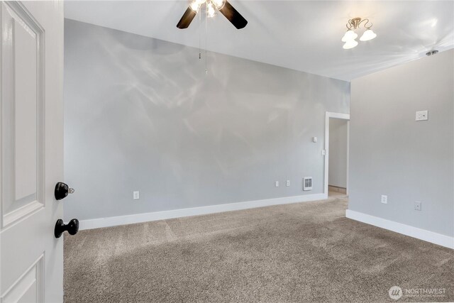 carpeted spare room with a ceiling fan, visible vents, and baseboards